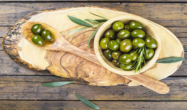 Aceitunas servidas en una tabla de olivo
